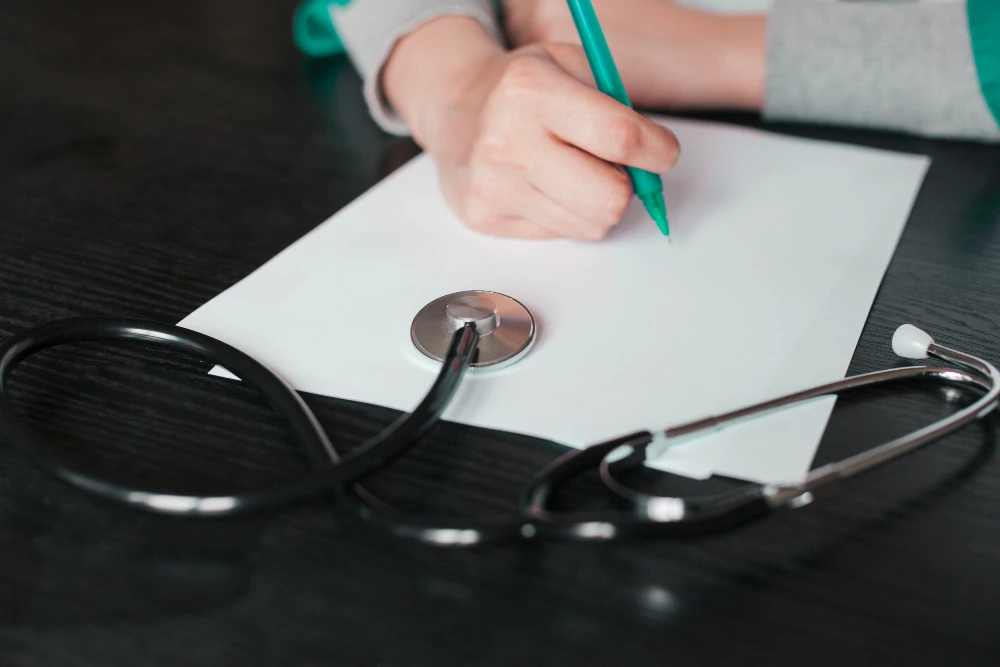 Doctor writing notes during USCIS-approved immigration medical exam in Houston clinic