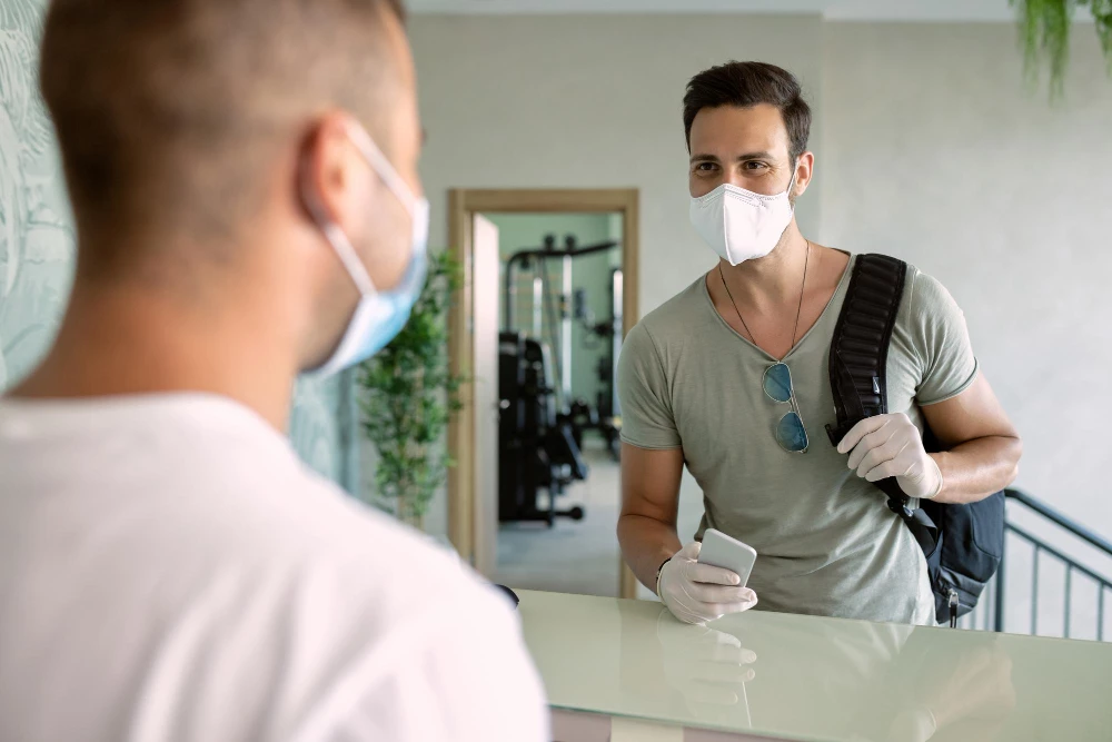 Masked individual at reception for immigration medical exam in Houston facility