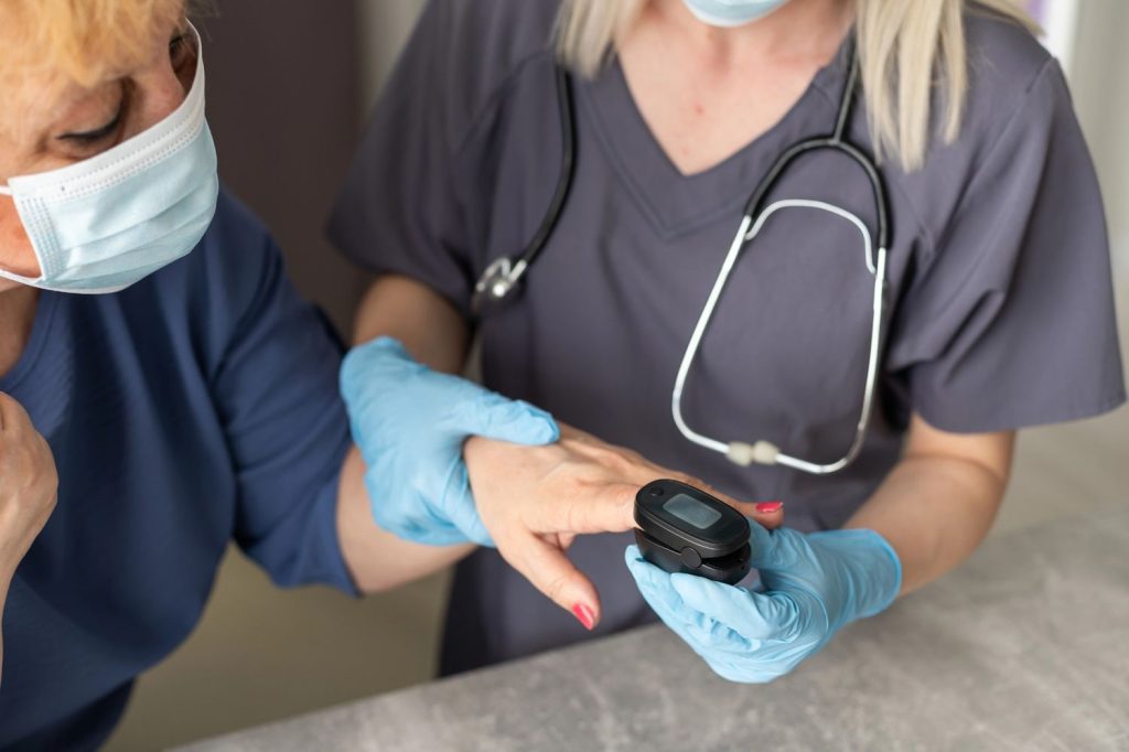 Healthcare worker monitors oxygen levels during cheapest immigration medical exam Houston for elderly patient care.