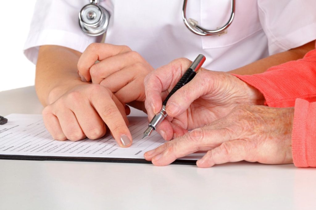 Healthcare provider assists patient with paperwork during cheapest immigration medical exam Houston documentation process.