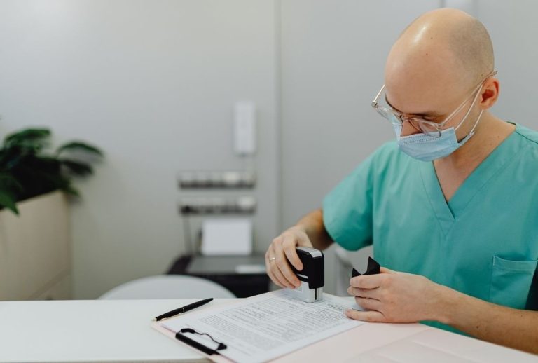 Healthcare worker stamping immigration exam paperwork for same day appointment at certified Houston medical clinic