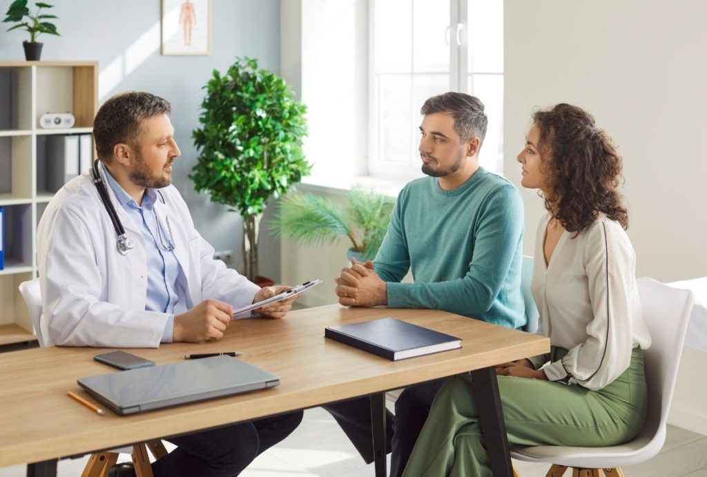 Doctor discusses results with couple during cheapest immigration medical exam Houston at certified medical office