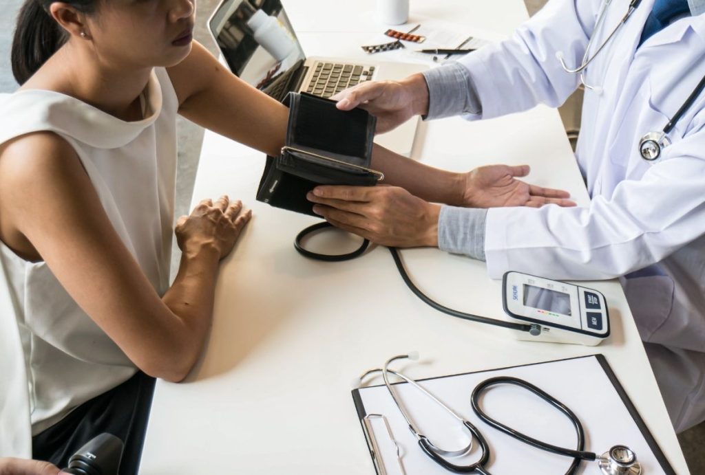 Healthcare provider checks blood pressure during cheapest immigration medical exam Houston in clinical setting.