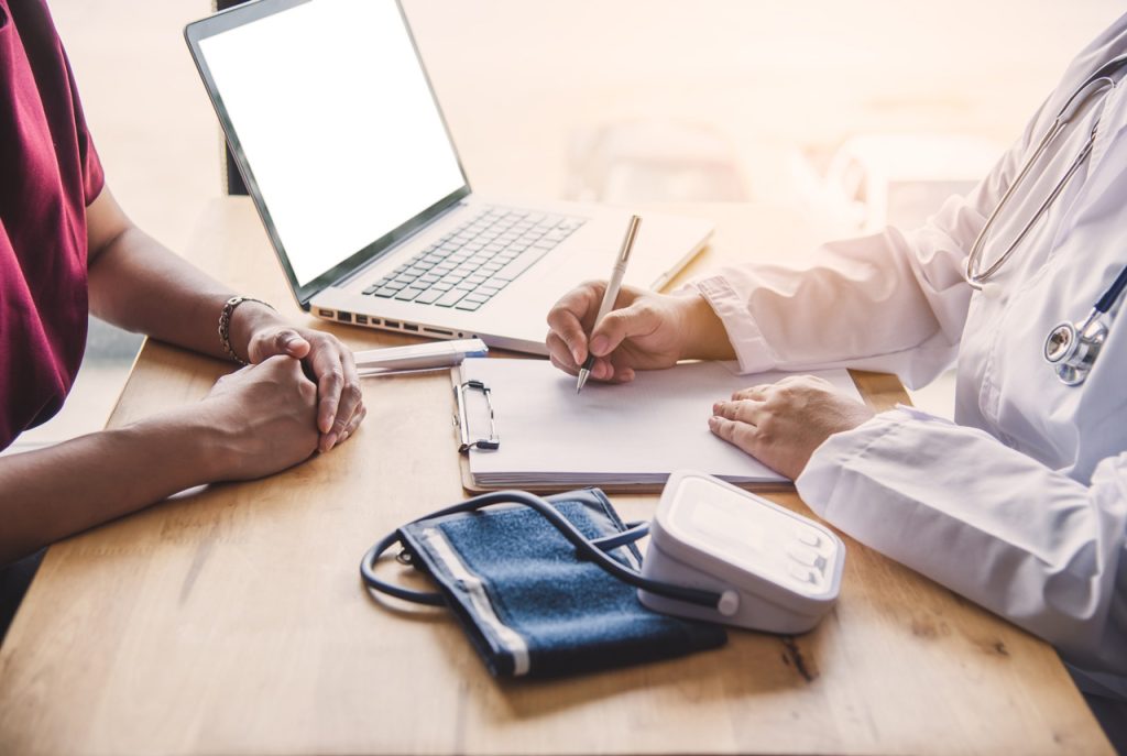 Professional consultation for an immigration medical exam Houston with a doctor reviewing patient history and vitals.