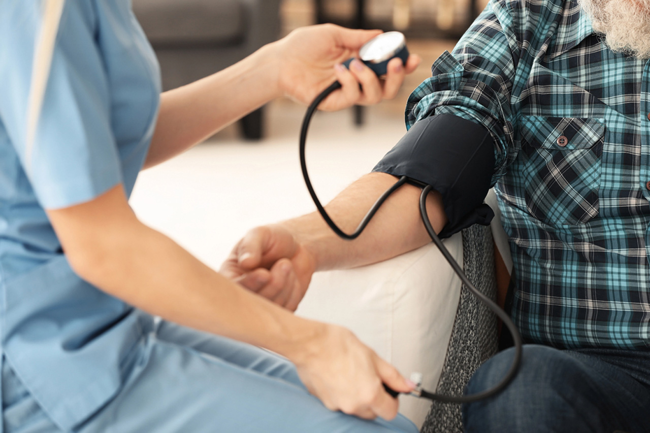 Nurse checking patient blood pressure for i 693 medical exam doctor Houston as part of required immigration health screening.