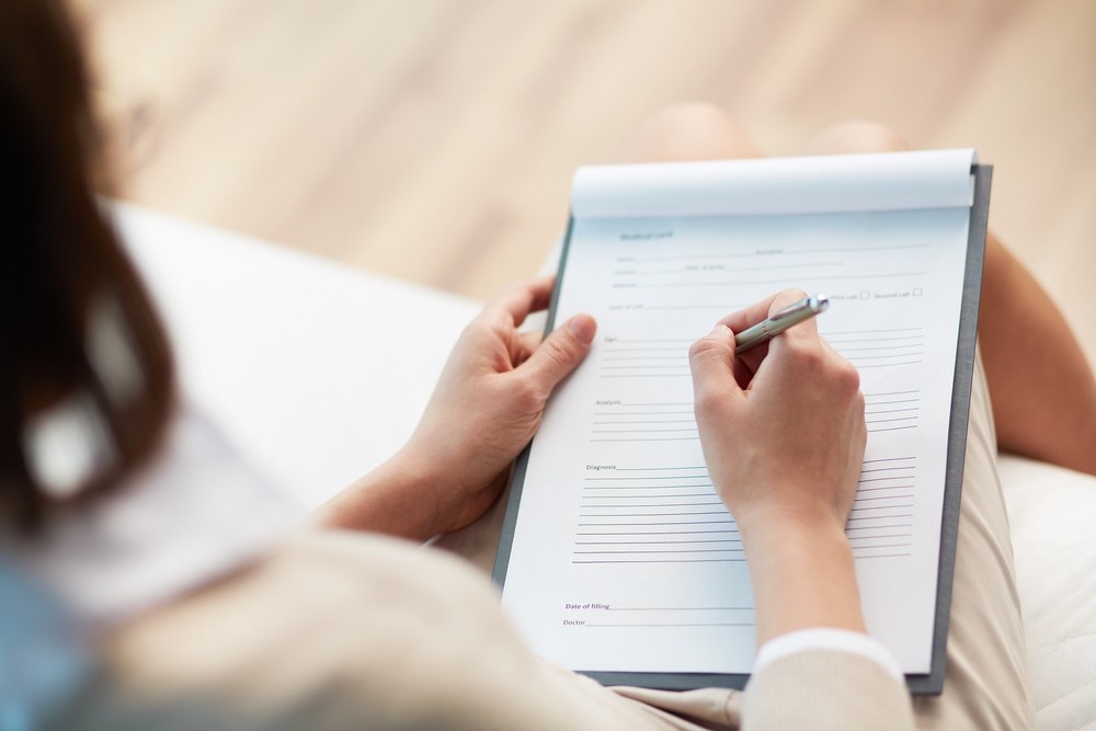 Doctor filling form for green card medical exam Houston physician office