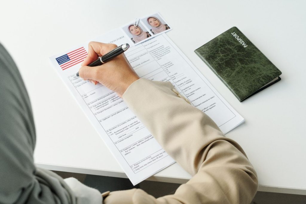 New patient signing registration papers at a local office while visiting a trusted immigration doctor Houston specialist. 