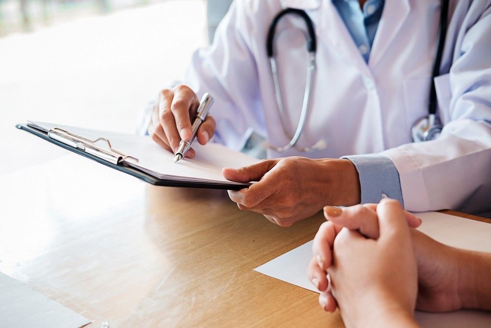 Physician signing paperwork for green card medical exam doctor Houston 